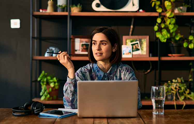 Person sitting at a table with their laptop