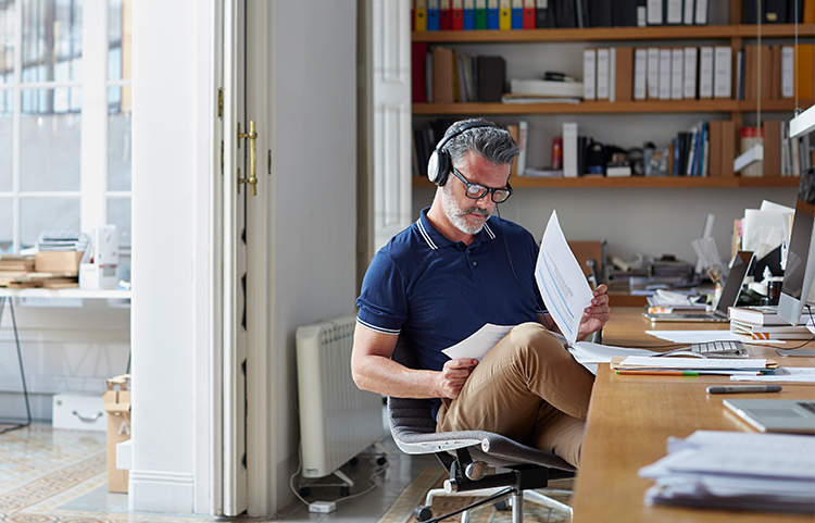 Man sitting at desk reviewing financial papers.